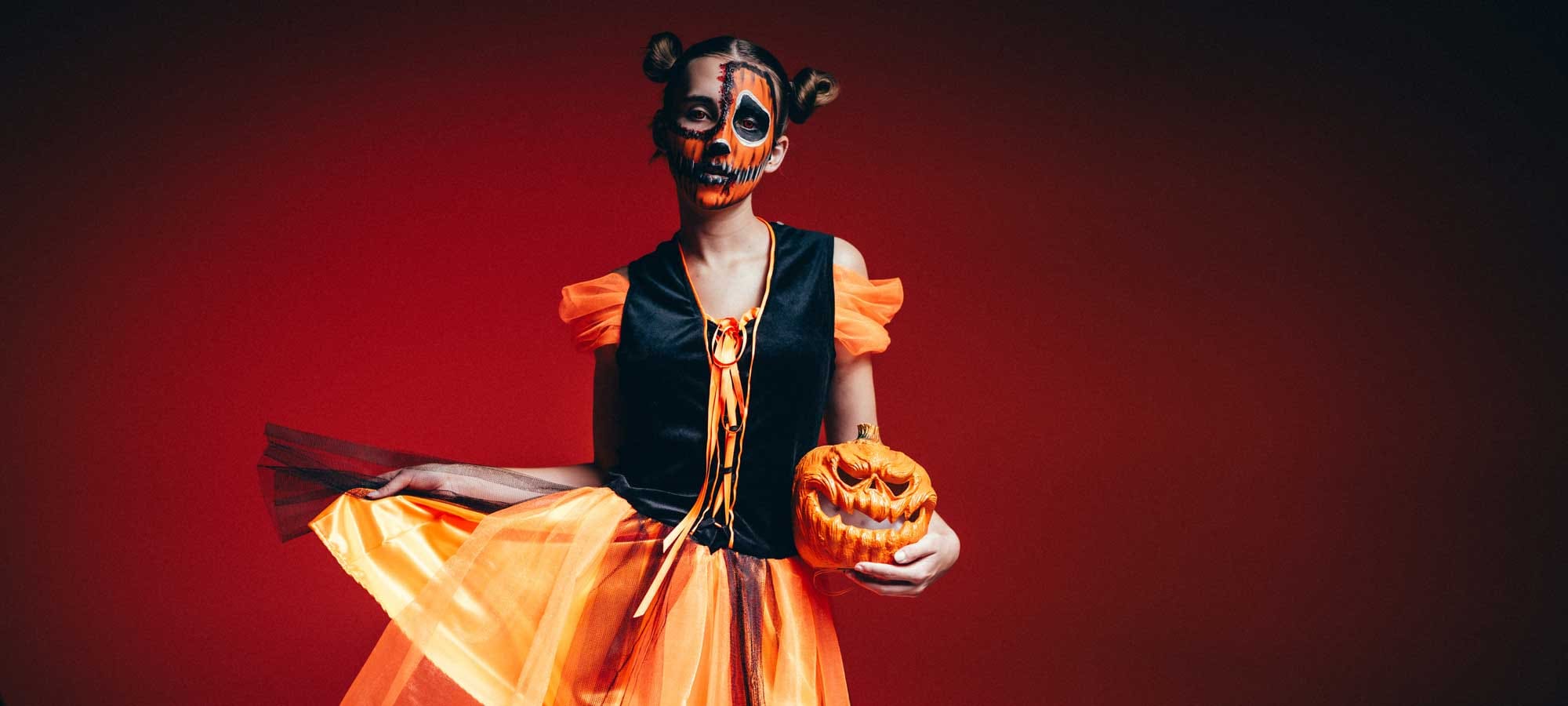 Eine Dame im orangefarbenem Hexenkostüm