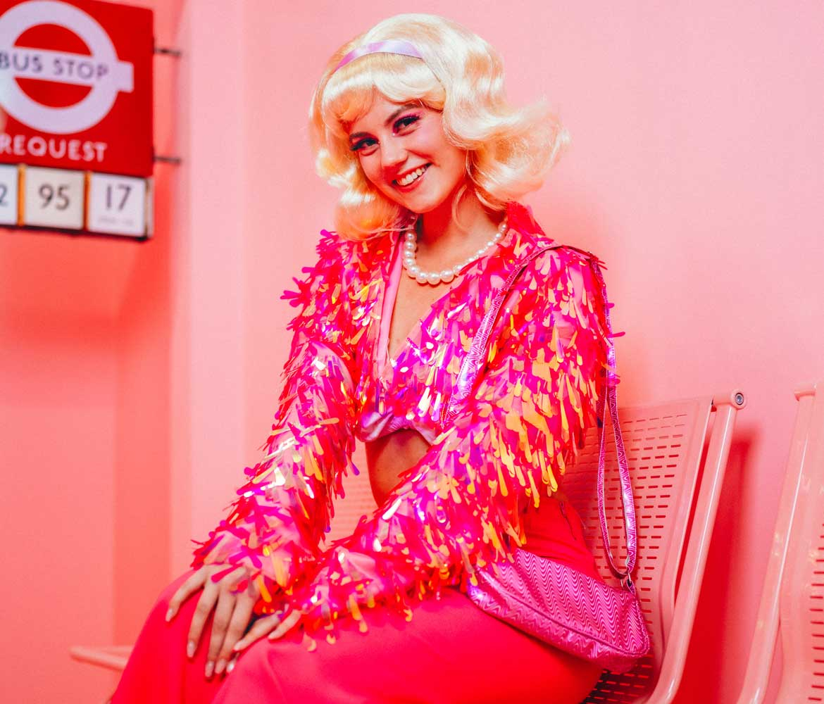 Eine Dame in pinker Paillettenjacke